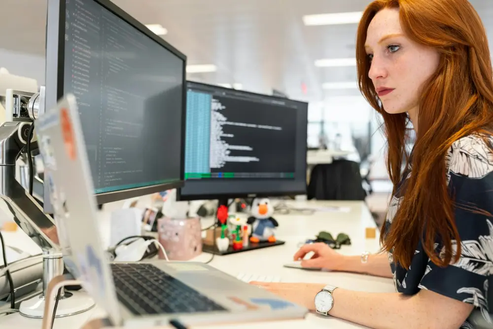 Female software engineer coding at a computer