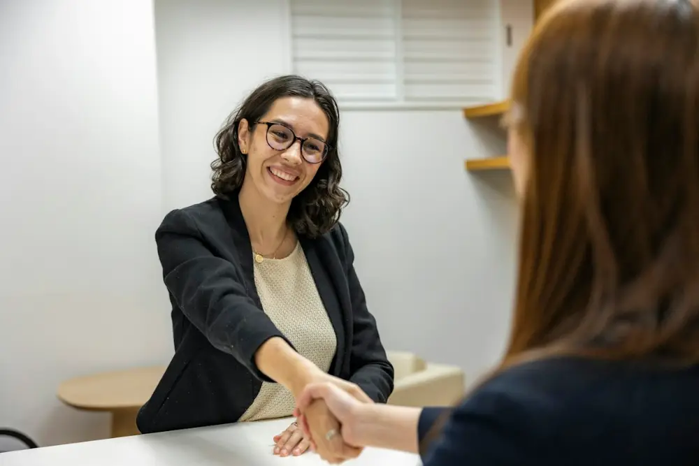 Fresh graduate shaking hands with a recruiter after a job interview