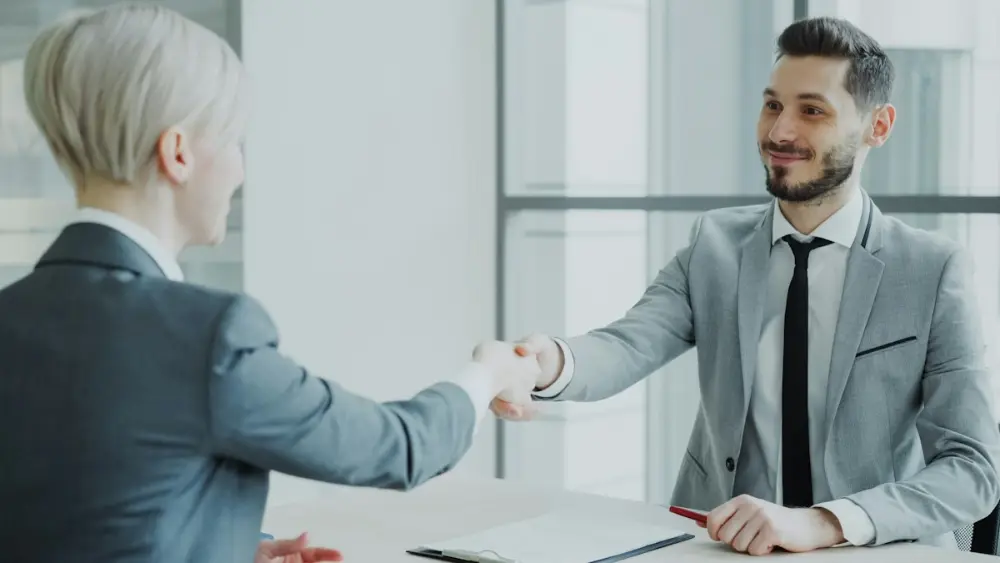 HR manager shaking hands with a candidate after an interview