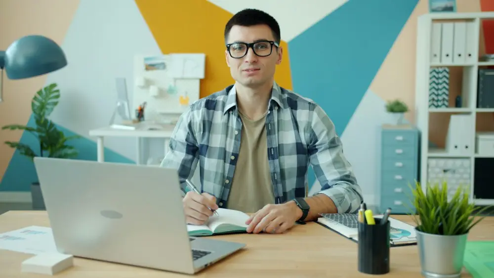 Online teacher planning lessons at a desk with a laptop