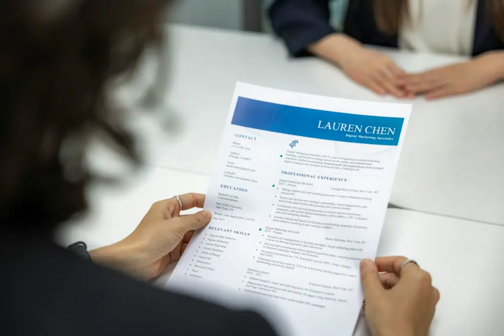 Recruiter reviewing a fresh graduate CV during an interview