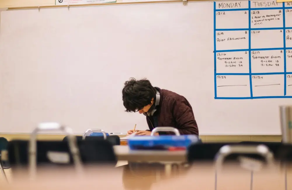 Student working at a desk in a classroom