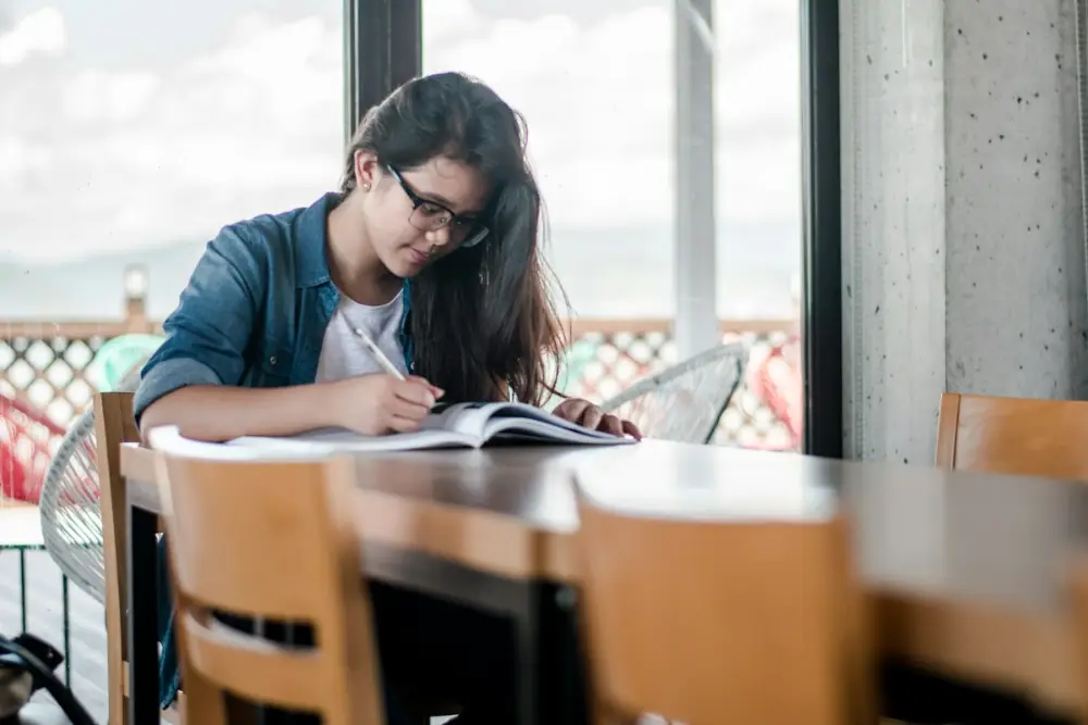 Student writing notes during exam revision