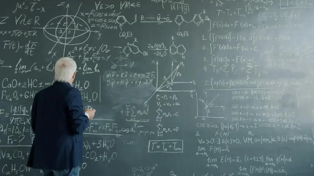 Teacher writing formulas on a chalkboard