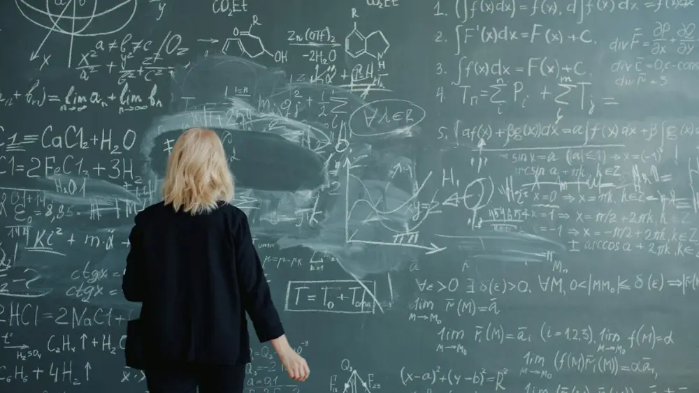 Teacher writing on a chalkboard during a demo class
