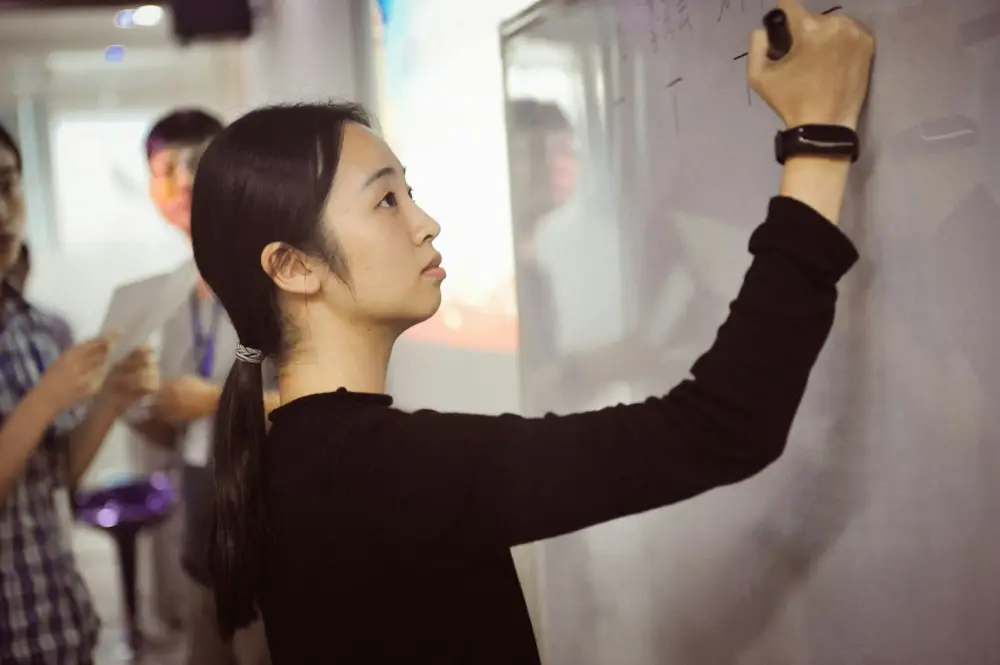 Teacher writing on a whiteboard in a classroom