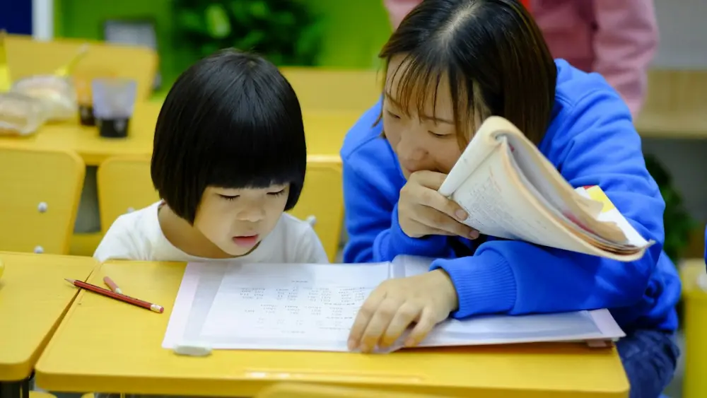Tutor giving one-to-one help to a young student