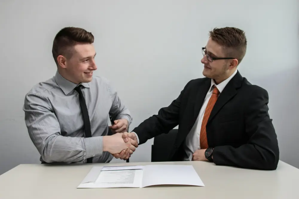 Two professionals shaking hands after a successful application